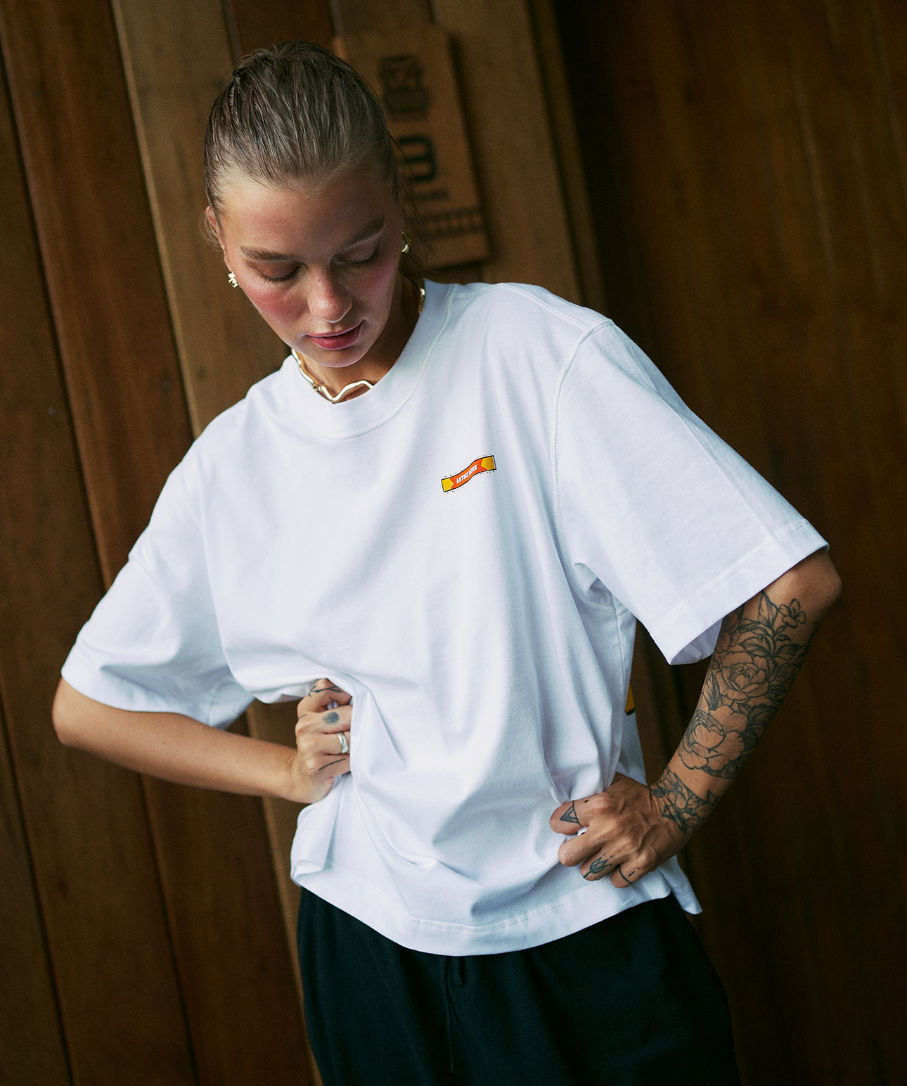Woman wearing white oversized cropped unisex t-shirt with minimal front logo by Artree Design