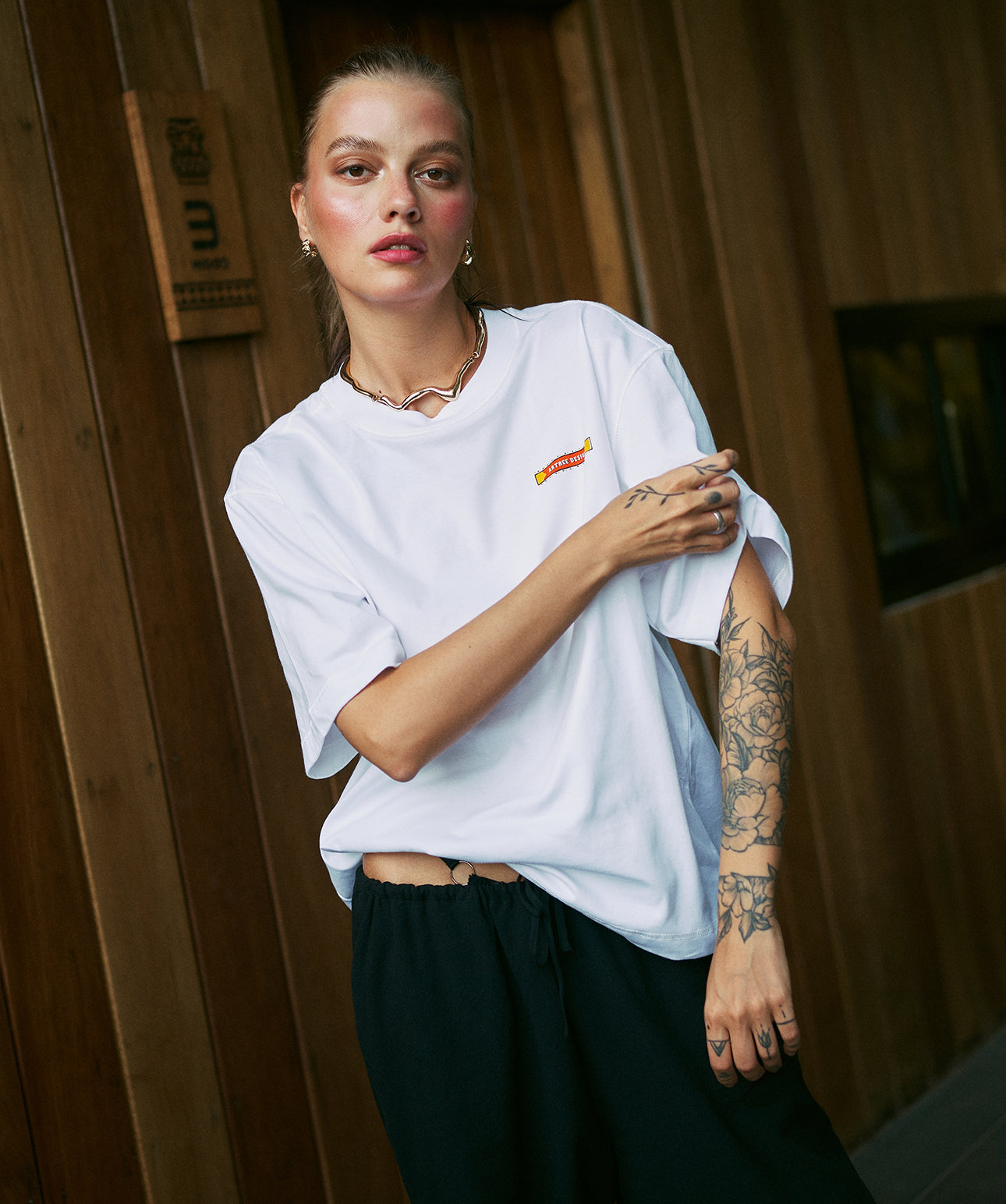 Close-up of white oversized cropped t-shirt with small Artree Design logo on chest – unisex fit