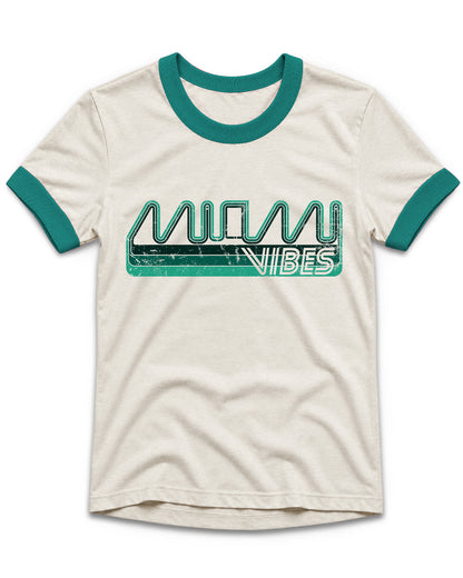 An off-white ringer t-shirt with teal trim on the collar and sleeve cuffs, featuring a distressed teal and white 'MIAMI VIBES' graphic across the chest.
