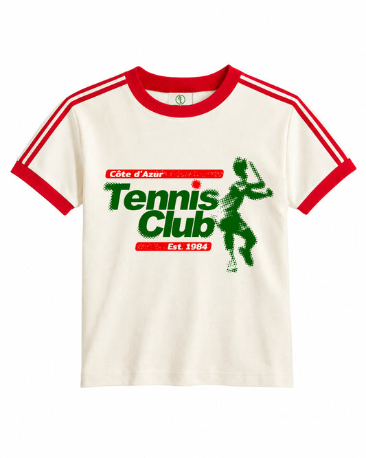 An off-white ringer t-shirt with red collar and sleeve trim, featuring a green and red graphic print on the front that reads 'Côte d'Azur Tennis Club Est 1984' alongside a tennis player silhouette.